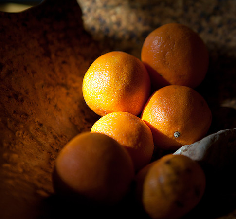 Oranges in a glass bowl with evening light